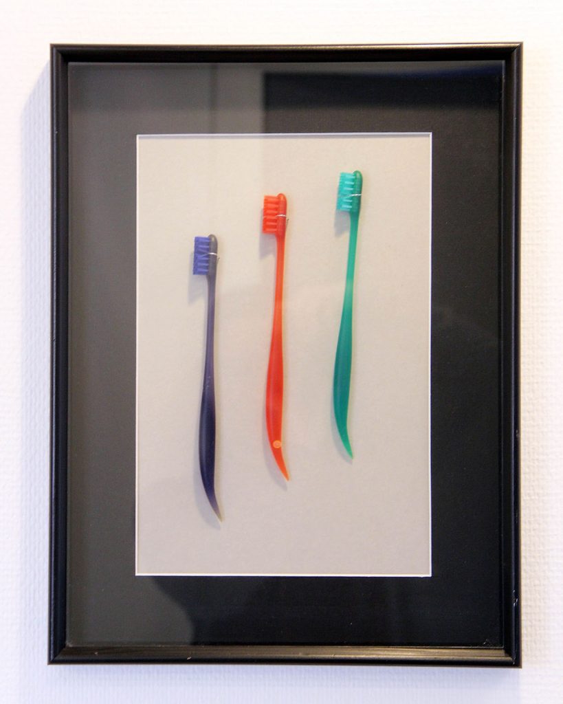 Tandborstar i olika färger uppsatta i en tavla.